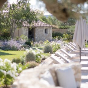 Muret de pierre et banquette d'extérieur, massifs de perovskia, de roses et de teucrium le long de la terrasse. Mas de Brunard