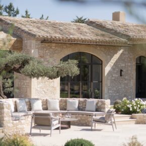 Canapé d'extérieur maçonné, construction en pierre traditionnelle, sous l'olivier, devant la baie cintrée