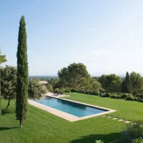 Depuis le mas on voit la piscine élancée et le paysage jusqu'au mont Ventoux. Les deux cyprès encadrent encore le chêne