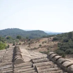 Les tuiles rondes du toit au premier plan, l'horizon vu depuis Eygalières