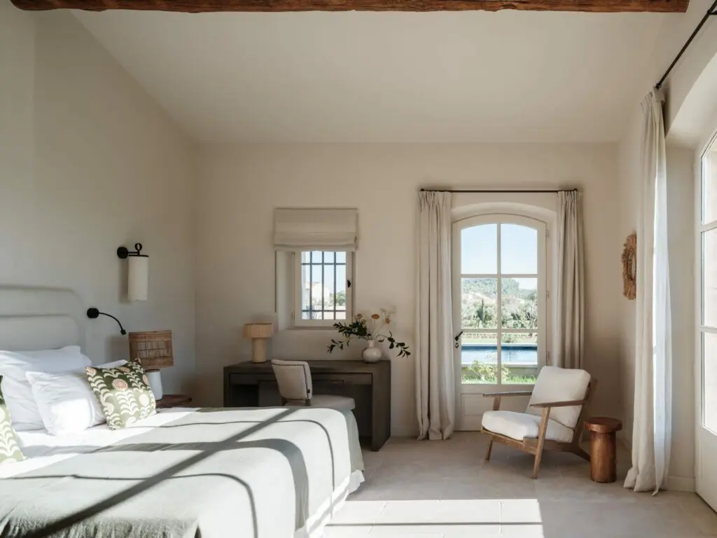 Chambre, fenêtre en bois cintrée ouverte sur la piscine, sol en pierre