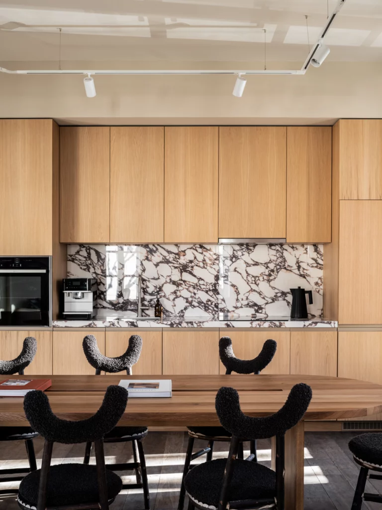 Cuisine de l'agence : façades de chêne, crédence de marbre, grande table et chaises Bosc Design. Bosc Architectes