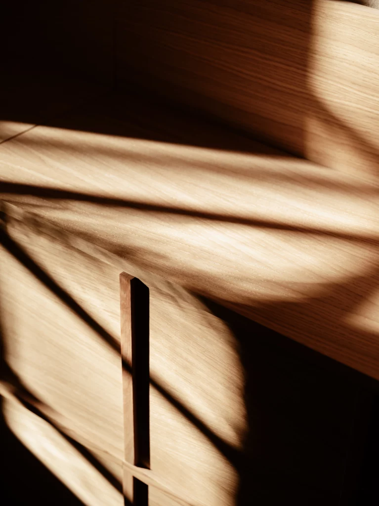 Détail d'une menuiserie de chêne : poignée creusée dans la masse, lumière de côté. Bosc Architectes