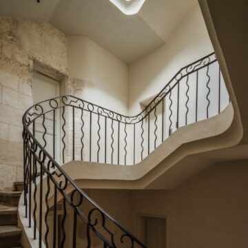 Inside, an immense staircase — almost the size of a grand reception room — unfolds over four floors. What a su